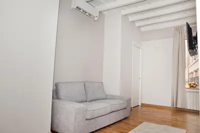a living room with a gray chair in a white room at Spanish Steps House Vittoria in Rome