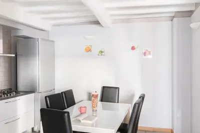 a kitchen with a white table and black chairs at Spanish Steps House Vittoria in Rome