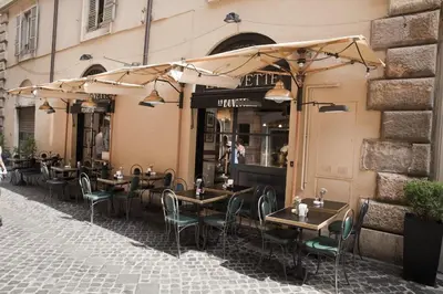 a restaurant with tables and chairs under umbrellas on a street at Spanish Steps House Vittoria in Rome