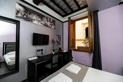 a bedroom with a bed and a desk and a mirror at Imperium Suite Navona in Rome