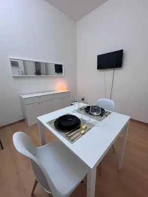 a white table and chairs in a white room at Golden Suite - un piccolo loft nel cuore di Roma in Rome