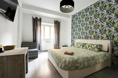 a bedroom with a bed with a floral wallpaper at Porta Portese Luxury Suites in Rome