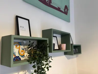 two green shelves on a wall with a plant at Porta Portese Luxury Suites in Rome