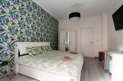 a bedroom with a bed with a tropical wallpaper at Porta Portese Luxury Suites in Rome