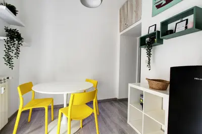 a dining room with yellow chairs and a white table at Porta Portese Luxury Suites in Rome