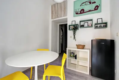 a dining room with a white table and yellow chairs at Porta Portese Luxury Suites in Rome