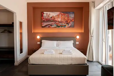 a bedroom with a bed and a painting on the wall at Flora Guest House in Rome