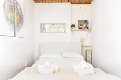 two beds in a white bedroom with white walls at Navona studio with terrace Backpackers in Rome