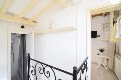 a hallway with white walls and a black railing at Navona studio with terrace Backpackers in Rome