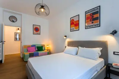 a bedroom with a large bed and a chair at Furio Flat in Rome