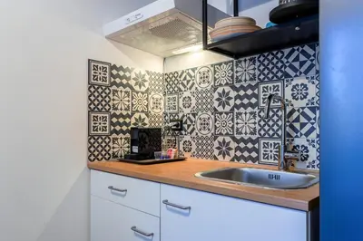 a kitchen with a sink and a tiled wall at Furio Flat in Rome