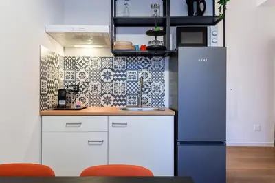 a kitchen with white cabinets and a blue refrigerator at Furio Flat in Rome