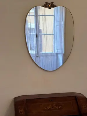 a mirror on a wall above a dresser with a window at Appartamento a Roma vicino Metro Vittorio Emanuele in Rome