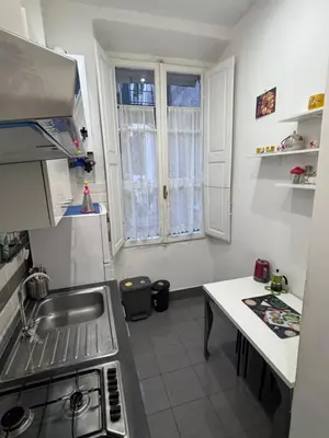 a small kitchen with a sink and a table at Appartamento a Roma vicino Metro Vittorio Emanuele in Rome