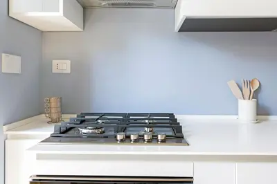 a stove top oven in a white kitchen at Luciano Boutique Apartment in Rome