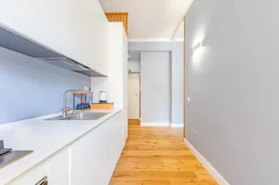 a kitchen with white countertops and a wooden floor at Luciano Boutique Apartment in Rome