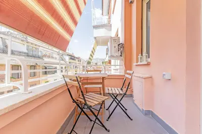 a balcony with two chairs and a table at Luciano Boutique Apartment in Rome