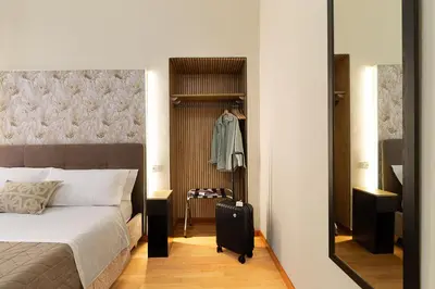 a bedroom with a bed with a suitcase and a mirror at Aras Luxury Flat in Rome