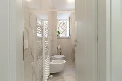 a white bathroom with a toilet and a sink at Aras Luxury Flat in Rome