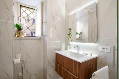 a white bathroom with a sink and a mirror at Aras Luxury Flat in Rome