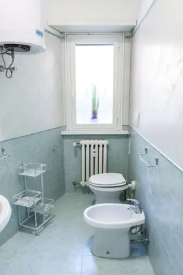 a bathroom with a toilet and a window and a sink at Menghini Easy Flat in Rome