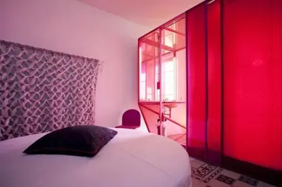 a bedroom with a bed and a window with red light at 3000rome Di Parione in Rome