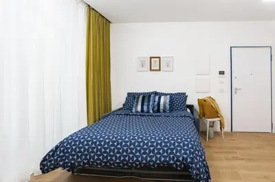 a bedroom with a bed with a blue and white comforter at La Saponeria - Roma Centro - Free Parking in Rome