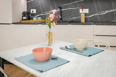a table with two bowls and a vase with flowers at La Saponeria - Roma Centro - Free Parking in Rome