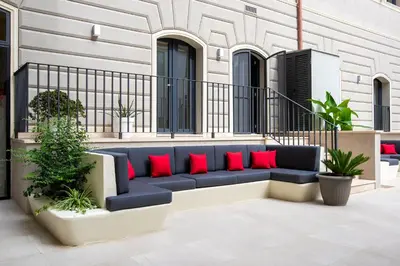 a blue couch with red pillows on a patio at Fortyfive Squared Hotel in Rome