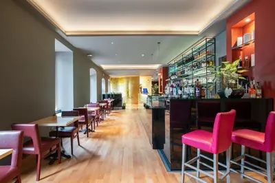 a restaurant with pink chairs and tables and a bar at Fortyfive Squared Hotel in Rome