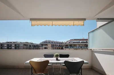 a table and chairs on a balcony with a large window at Trastevere-Colosseo, Elegant Apartment Wi-Fi & A-C in Rome