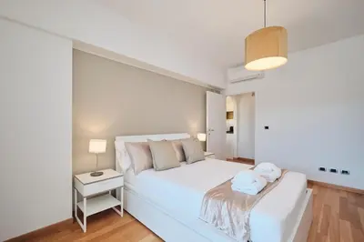 a white bedroom with a white bed and a table at Trastevere-Colosseo, Elegant Apartment Wi-Fi & A-C in Rome