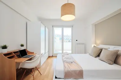 a bedroom with a bed and a desk with a laptop at Trastevere-Colosseo, Elegant Apartment Wi-Fi & A-C in Rome