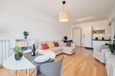 a living room with a white couch and a table at Trastevere-Colosseo, Elegant Apartment Wi-Fi & A-C in Rome