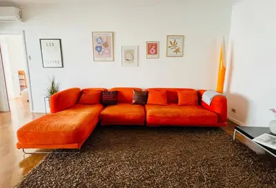 an orange couch sitting in a living room at Attico 22 in Rome