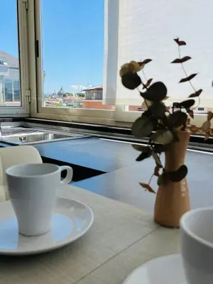a table with a coffee cup and a vase with a plant at Attico 22 in Rome