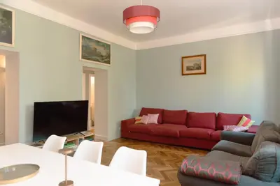 a living room with a red couch and a tv at Tiber Luxury Apartment in Rome