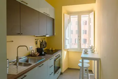 a kitchen with white cabinets and a sink and a window at Tiber Luxury Apartment in Rome