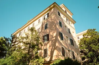 a tall white building with trees in front of it at Tiber Luxury Apartment in Rome