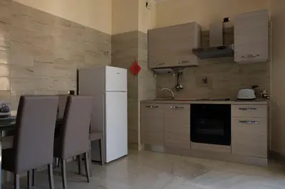 a kitchen with a white refrigerator and a table and chairs at Spanish Steps Studio in Rome