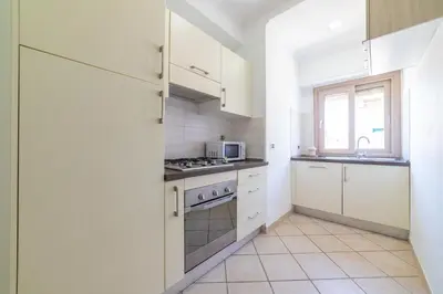 a kitchen with white cabinets and a stove top oven at Bubu's Home by Holiday World in Rome
