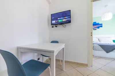 a white table and chairs with a tv on a wall at Bubu's Home by Holiday World in Rome
