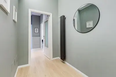 a hallway with a round mirror on a wall at Domus Suite Gemelli - Relax & Comfort in Rome