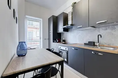 a kitchen with a table with chairs and a sink at Domus Suite Gemelli - Relax & Comfort in Rome