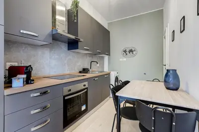 a kitchen with a sink and a table with chairs at Domus Suite Gemelli - Relax & Comfort in Rome