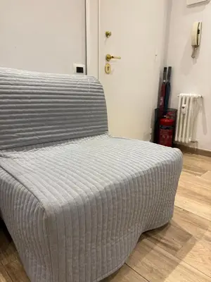 a bed in a room with a gray blanket at Vatican Walls Studio in Rome