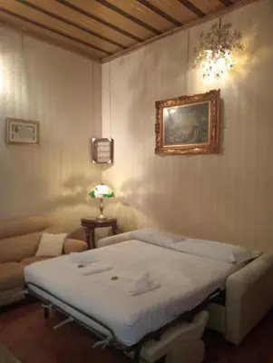 a room with a bed and a couch and a picture at Dimora Armanda Roma in Rome