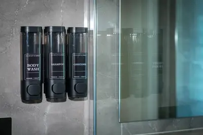 a group of black bottles on a glass shelf at The Suitest Roma Apartment Appio Latino in Rome