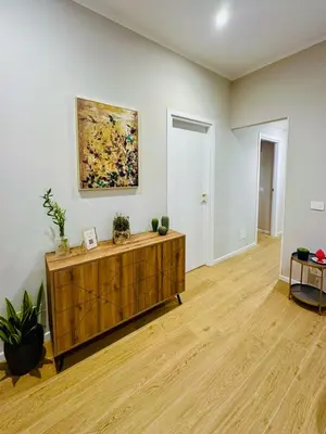 a living room with a wooden cabinet and a painting on the wall at The Suitest Roma Apartment Appio Latino in Rome