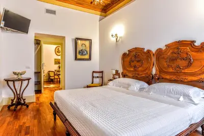 a bedroom with a large bed with a wooden headboard at Casa Arpinelli in Rome